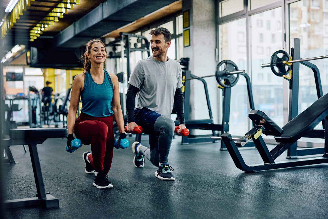 Two friends working out together in a modern gym