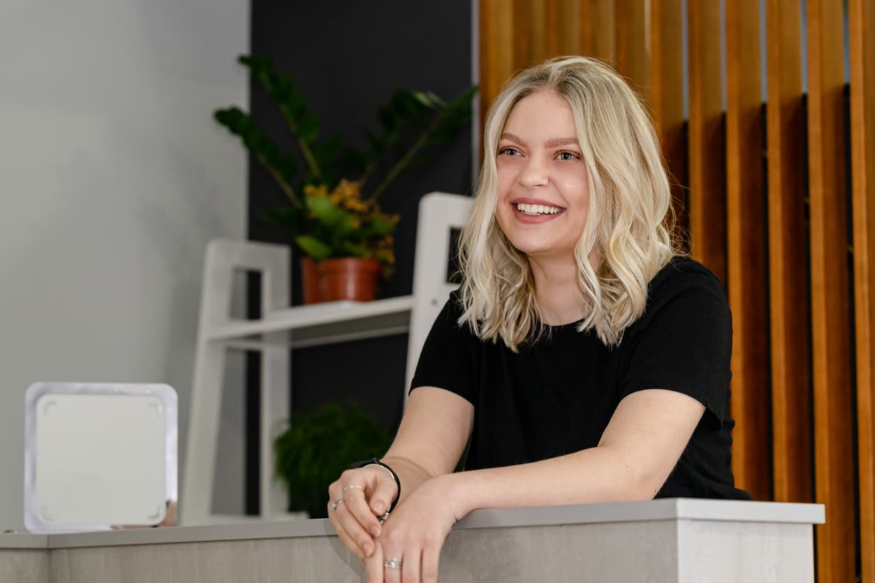 A salon receptionist smiling at incoming clients